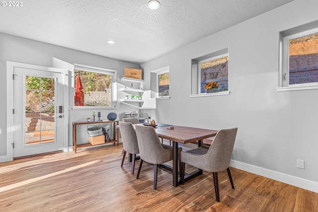 dining space featuring hardwood / wood-style floors and a textured ceiling