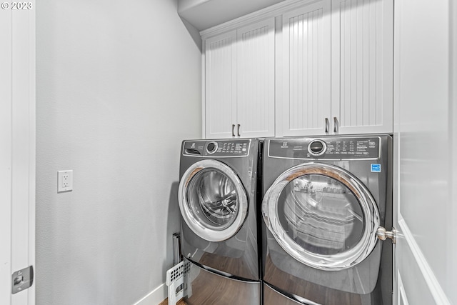 laundry area with cabinets and washing machine and clothes dryer