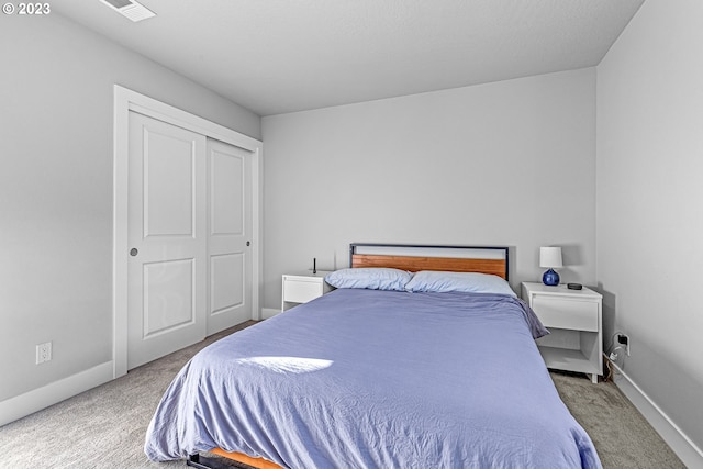 bedroom with a closet and light carpet