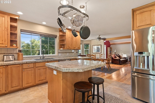 kitchen with ceiling fan, sink, backsplash, and stainless steel fridge