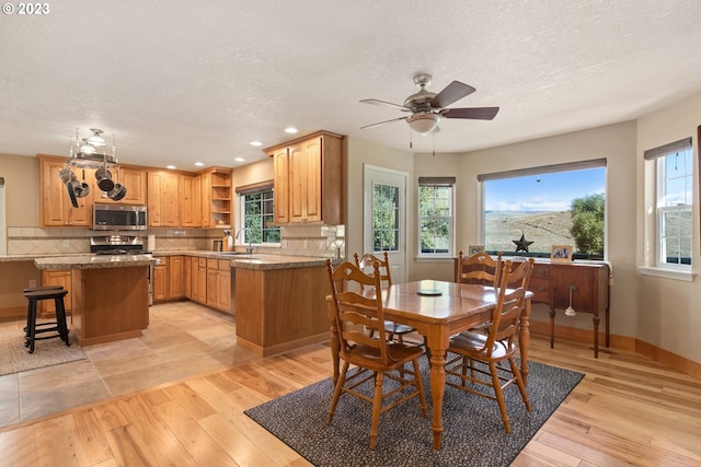 tiled dining area with a textured ceiling, ceiling fan, and sink