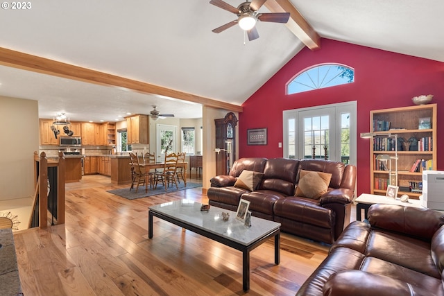 living room with beamed ceiling, light hardwood / wood-style floors, and plenty of natural light