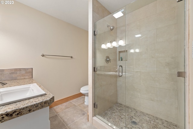 bathroom with vanity, walk in shower, tile flooring, and toilet