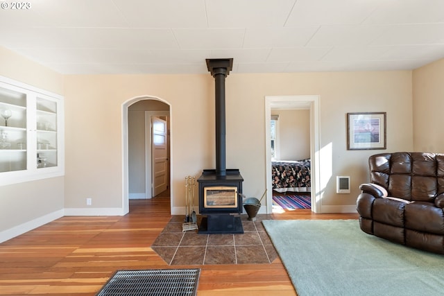 living room featuring a wood stove and dark hardwood / wood-style floors