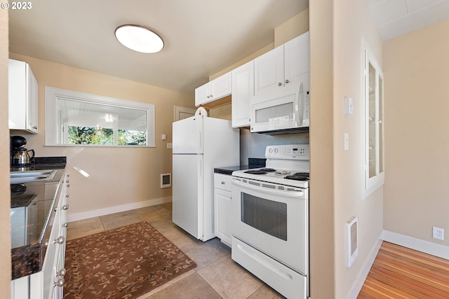 kitchen featuring light tile flooring, sink, white appliances, and white cabinetry