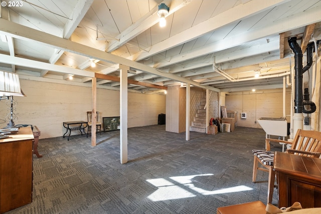 basement featuring dark colored carpet and sink