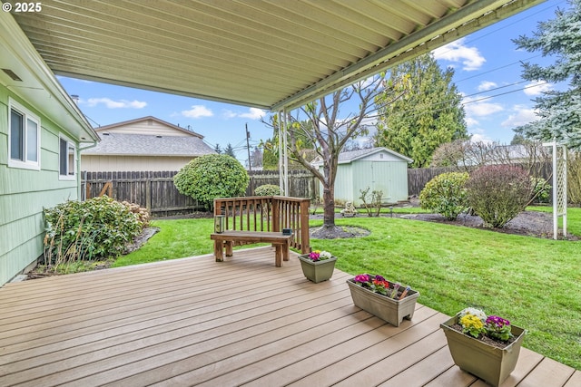 wooden terrace with a fenced backyard, an outdoor structure, and a yard