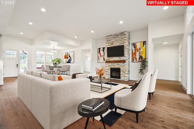 living room featuring a fireplace, an inviting chandelier, and hardwood / wood-style flooring