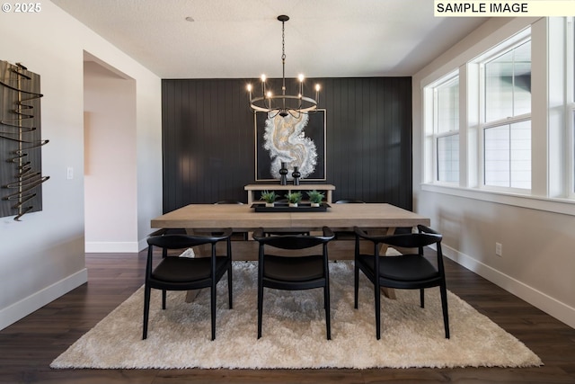 Mountain Home Rd, Sherwood, OR 97140 - dining space featuring a chandelier, baseboards, an accent wall, and dark wood-type flooring