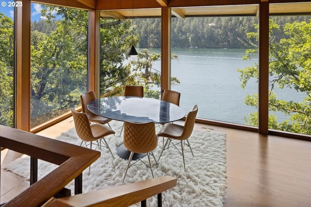 sunroom / solarium featuring a water view