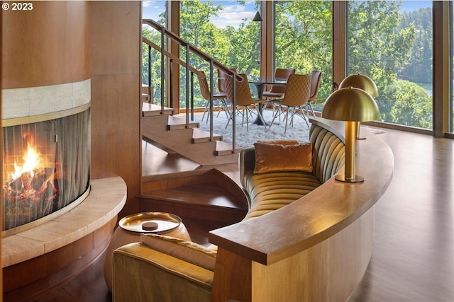 interior space featuring a wealth of natural light, wood-type flooring, and a tiled fireplace