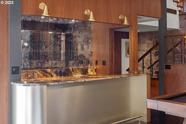 bar with dark stone counters and billiards