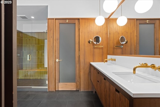 bathroom featuring a shower with door, double sink, large vanity, and tile flooring