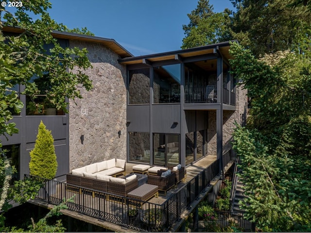 back of house featuring a balcony and an outdoor living space