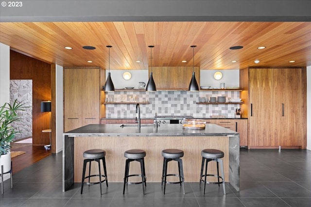 kitchen featuring hanging light fixtures, a kitchen breakfast bar, and sink