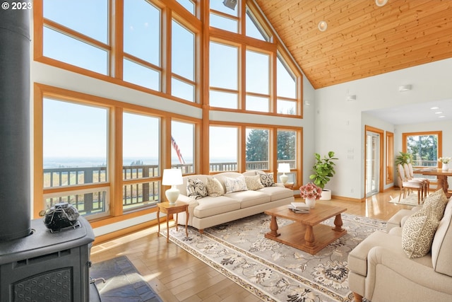 22000 SE Upper Matthews Creek Ln, Amity, OR 97101 - living room featuring high vaulted ceiling, wooden ceiling, a wood stove, and light hardwood / wood-style flooring