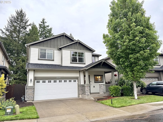 craftsman-style home featuring board and batten siding, a porch, concrete driveway, an attached garage, and fence