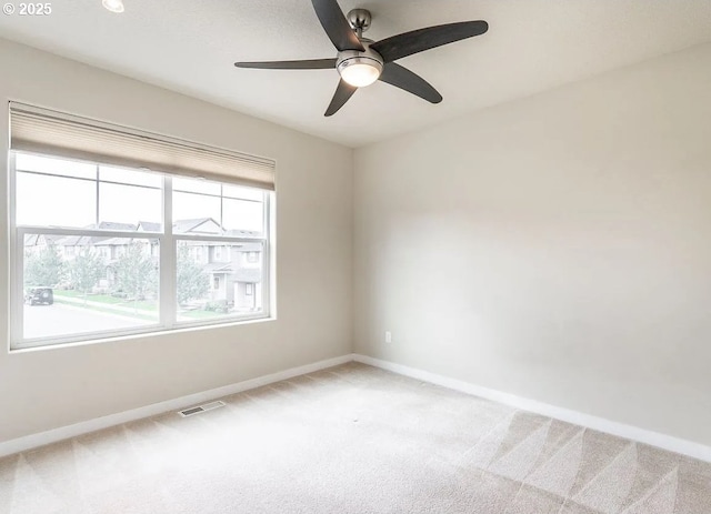 spare room with light carpet, baseboards, and a ceiling fan