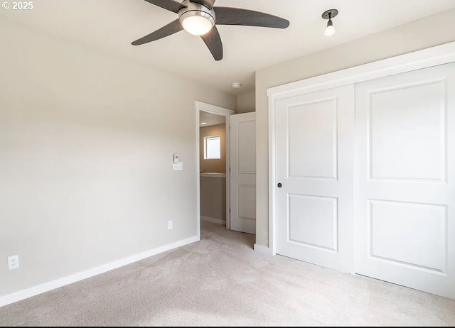 unfurnished bedroom featuring light carpet, baseboards, a closet, and ceiling fan
