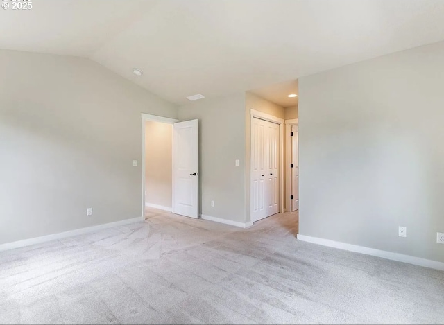 spare room with light colored carpet, baseboards, recessed lighting, and lofted ceiling
