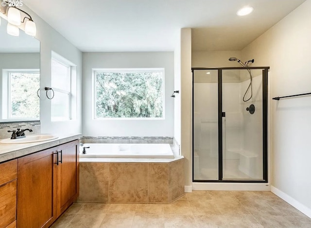 bathroom with a stall shower, a garden tub, vanity, and tile patterned flooring
