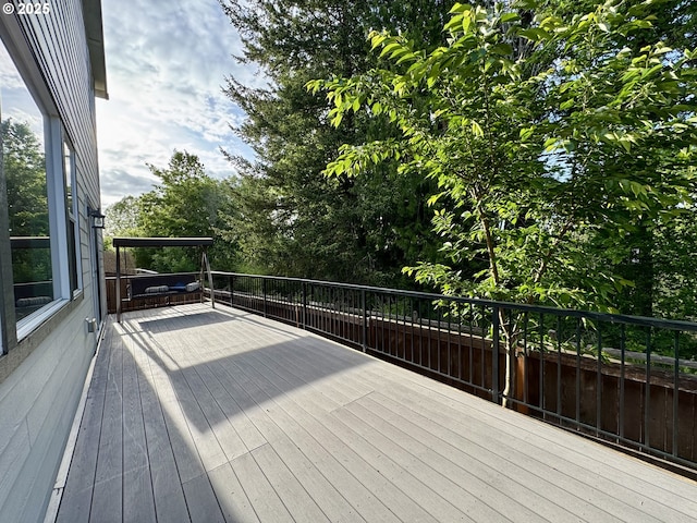 wooden terrace with view of wooded area