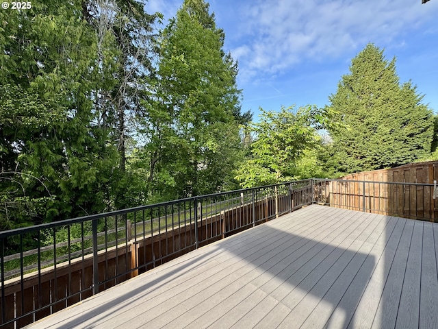 wooden terrace with a fenced backyard