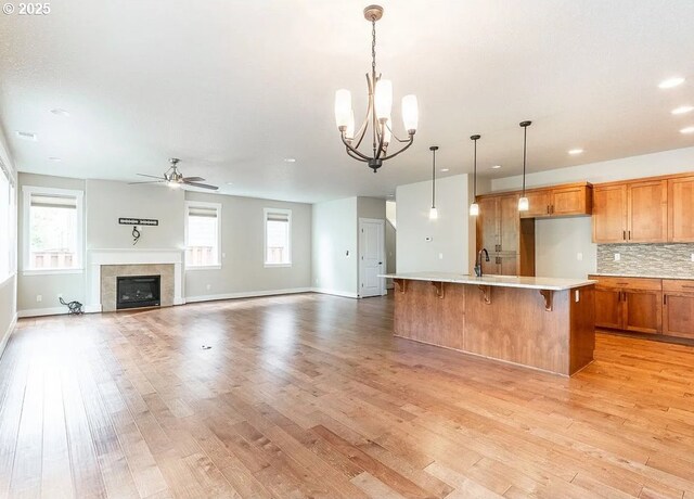 kitchen featuring ceiling fan, light countertops, light wood-style flooring, brown cabinets, and recessed lighting