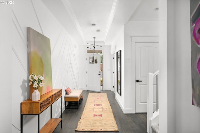 corridor featuring dark wood finished floors, crown molding, and baseboards