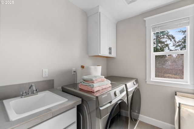 laundry room featuring a sink, visible vents, baseboards, independent washer and dryer, and cabinet space