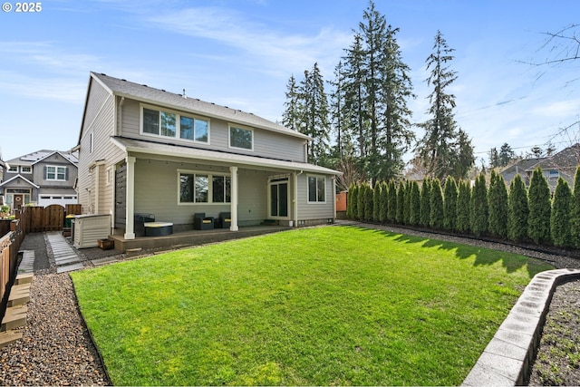 rear view of house featuring a lawn, a patio area, and a fenced backyard