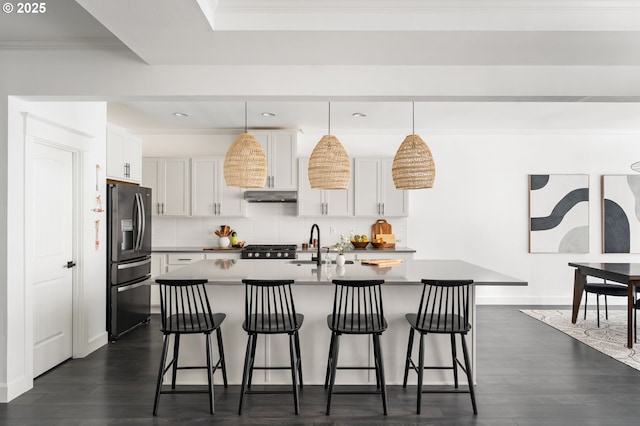 kitchen featuring ornamental molding, stainless steel refrigerator with ice dispenser, and a kitchen breakfast bar