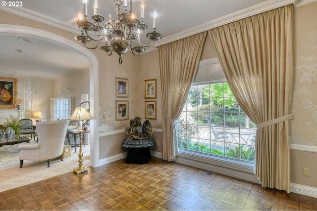 entryway featuring crown molding, parquet flooring, and a chandelier