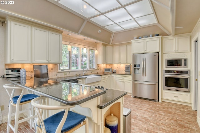 kitchen with tasteful backsplash, stainless steel appliances, kitchen peninsula, hanging light fixtures, and a kitchen breakfast bar