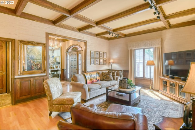 living room featuring coffered ceiling, an inviting chandelier, and beamed ceiling