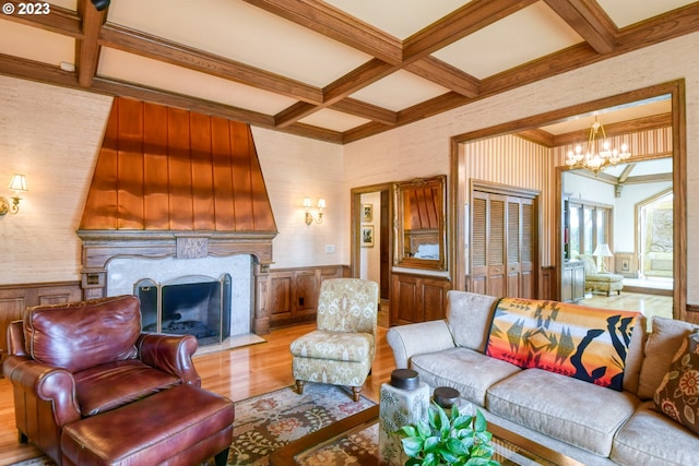 living room featuring coffered ceiling, beam ceiling, light wood-type flooring, and a chandelier