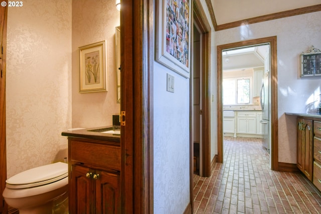 bathroom with ornamental molding, toilet, and vanity