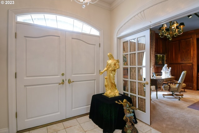 entrance foyer with ornamental molding, a notable chandelier, and light tile floors