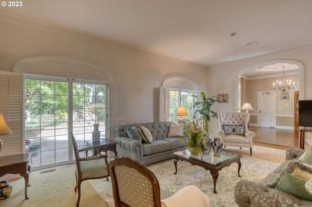 living room with crown molding, light hardwood / wood-style flooring, a wealth of natural light, and a chandelier