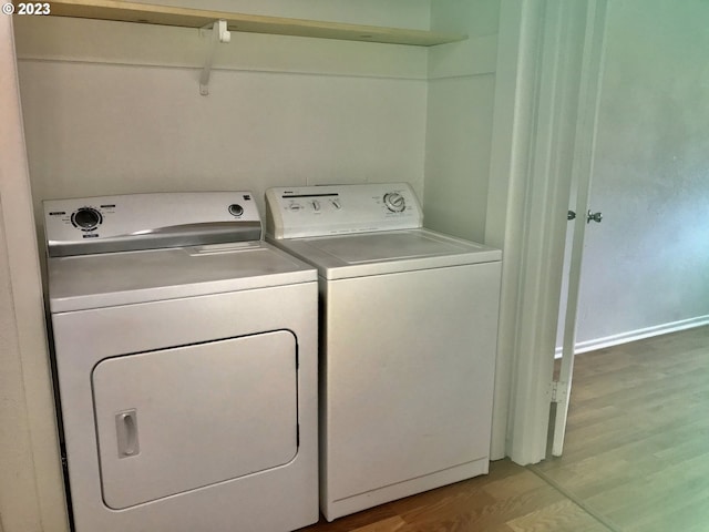 laundry area with light hardwood / wood-style floors and washer and dryer