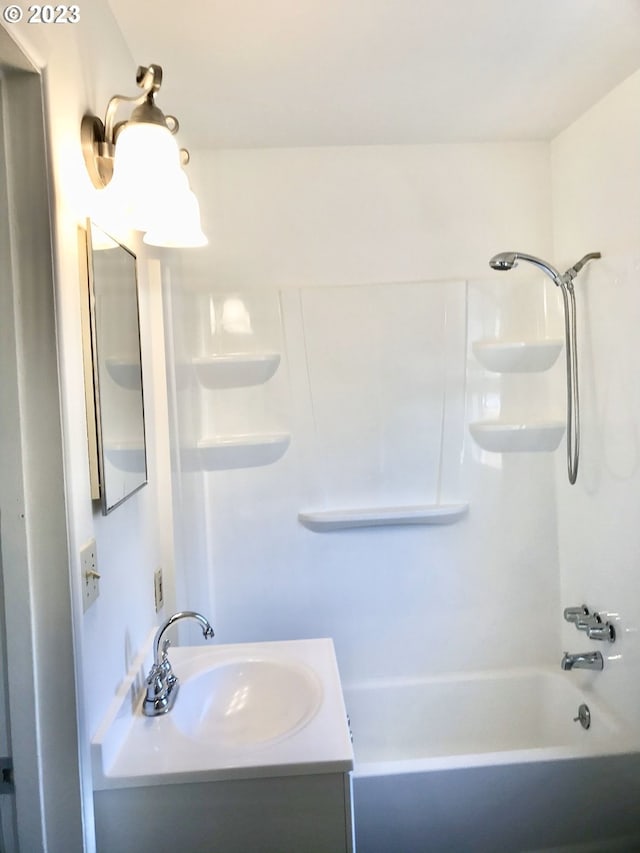 bathroom with vanity with extensive cabinet space and washtub / shower combination