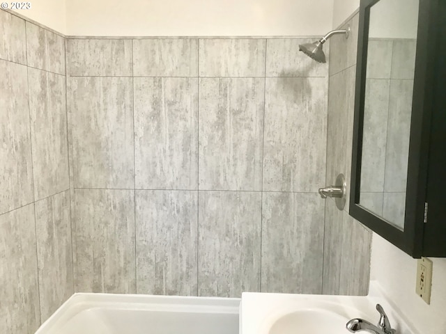 bathroom with sink and tiled shower / bath