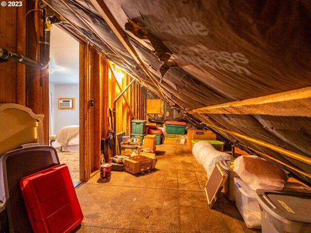 unfinished attic with a wall unit AC