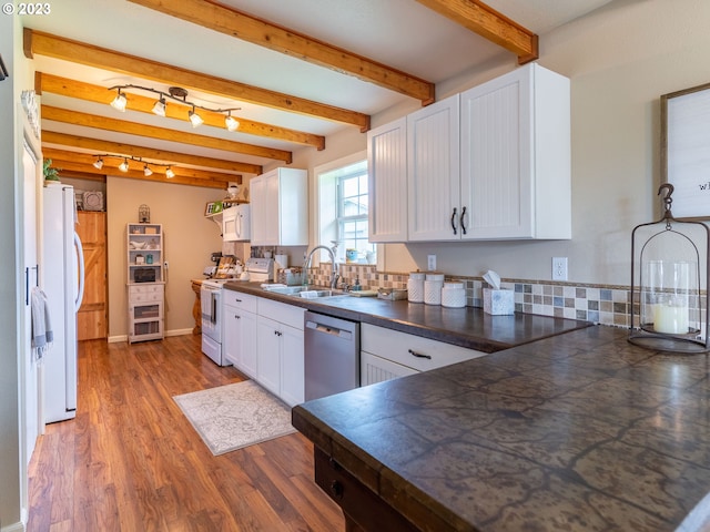 kitchen with beam ceiling, white appliances, white cabinets, backsplash, and sink