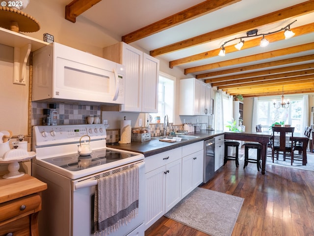 kitchen featuring white appliances, plenty of natural light, and beamed ceiling