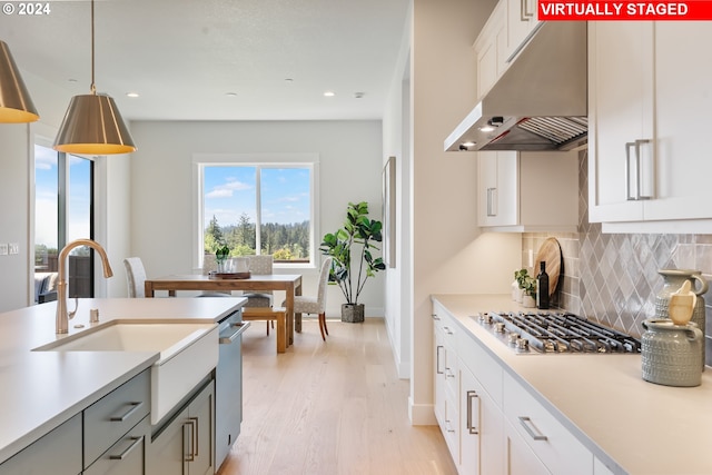 kitchen featuring pendant lighting, white cabinetry, gray cabinetry, backsplash, and stainless steel gas cooktop