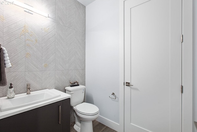 bathroom with toilet, vanity, and wood-type flooring