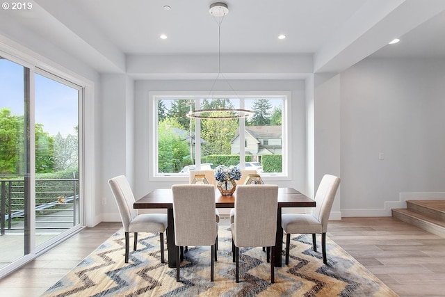 dining area featuring a notable chandelier, a wealth of natural light, and light wood-type flooring