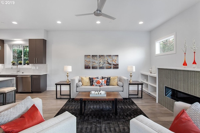 living room with ceiling fan, a healthy amount of sunlight, and light wood-type flooring