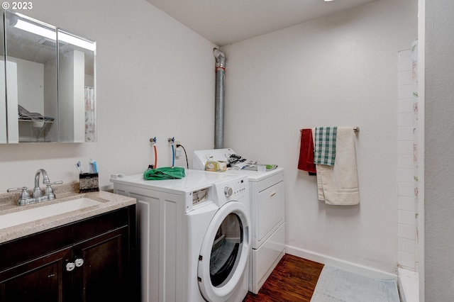 washroom featuring washer hookup, separate washer and dryer, dark wood-type flooring, and sink